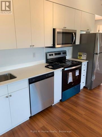 Brantford condo for rent - A kitchen with white cabinets and a stainless steel dishwasher.
