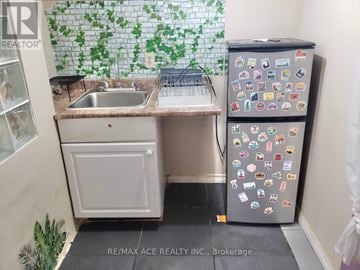 Mississauga (Malton) apartment for rent - A small kitchen with a sink and a refrigerator with many magnets.