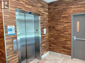 Waterloo condo for rent - A glass door with a handle and a red emergency sign on it.