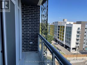 Waterloo condo for rent - A balcony with a view of a parking lot and buildings.