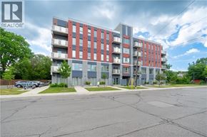 Hamilton condo for rent - A multi-story apartment building with a parking lot in front.