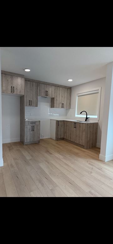 Edmonton apartment for rent - A kitchen with wooden cabinets and a window.