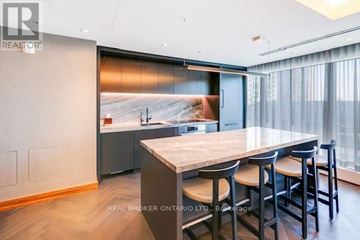 Toronto (Waterfront Communities) condo for rent - A modern kitchen with a dining table and chairs.