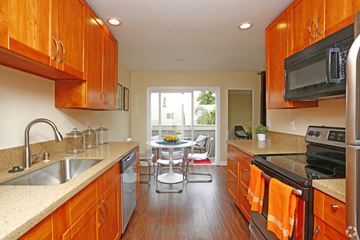 San Jose apartment for rent - a kitchen with wooden cabinets and a table with chairs