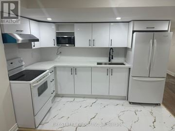 Bradford West Gwillimbury (Bradford) apartment for rent - A white kitchen with marble flooring and a refrigerator on the right.