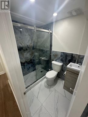 Bradford West Gwillimbury (Bradford) apartment for rent - A white toilet in a glass enclosed shower stall.