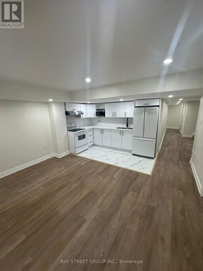Bradford West Gwillimbury (Bradford) apartment for rent - A large empty room with wooden floors and white walls.