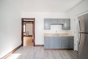 Chicago apartment for rent - an empty kitchen with blue cabinets and a stainless steel refrigerator