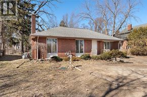 Kingsville apartment for rent - A house with a brown brick exterior and a grey roof is surrounded by a dirt lot.