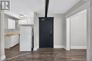 Hamilton (Stipley) multi-family for rent - A kitchen with white cabinets and a black door.