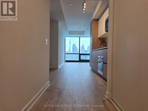 Toronto (Waterfront Communities) condo for rent - A hallway with a view of a city skyline through the windows.