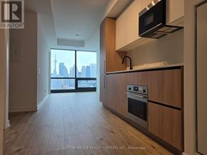Toronto (Waterfront Communities) condo for rent - A kitchen with wooden cabinets and a stainless steel oven.