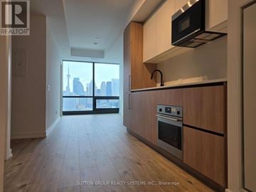 Toronto (Waterfront Communities) condo for rent - A kitchen with wooden cabinets and a stainless steel oven.