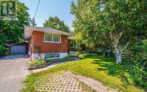 Oshawa (Mclaughlin) apartment for rent - A red brick house with a white garage door and a white window.