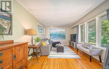 Oshawa (Mclaughlin) apartment for rent - A living room with a couch, chair, and a painting on the wall.