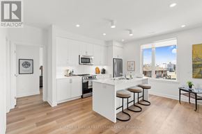 Ottawa condo for rent - A modern kitchen with white cabinets and a bar area.