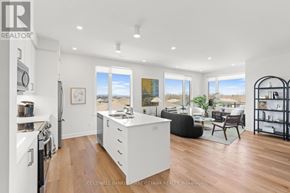 Ottawa condo for rent - A modern kitchen with white appliances and wooden floors.
