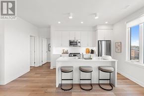 Ottawa condo for rent - A modern kitchen with white cabinets and a bar stool.