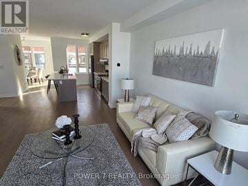 Markham townhouse for rent - A living room with a grey coffee table and a grey sofa with a white cushion.