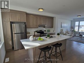 Markham townhouse for rent - A kitchen with a refrigerator, stove, and bar stools.