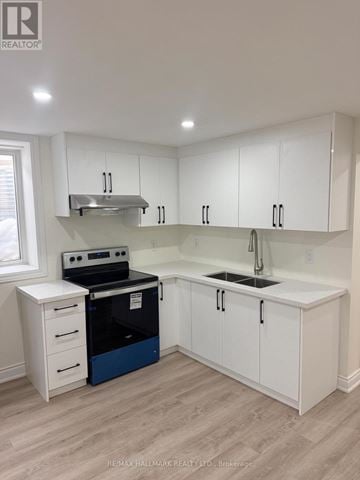 Milton (Co Coates) apartment for rent - A kitchen with white cabinets and a blue dishwasher.
