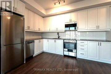Oakville (Wm Westmount) condo for rent - A kitchen with white cabinets and a stainless steel refrigerator.