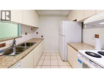 Vancouver apartment for rent - A small kitchen with a white refrigerator and a white stove.