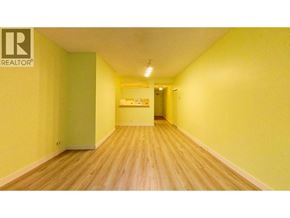 Vancouver apartment for rent - A long hallway with a green door and a Realtor sign on the wall.