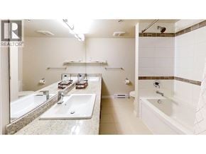 Richmond apartment for rent - A bathroom with a sink, mirror, and bathtub.