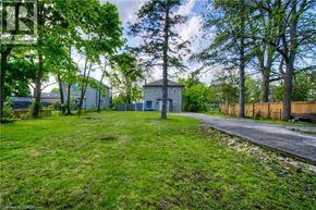 Cambridge apartment for rent - A house is surrounded by a grassy area and trees.