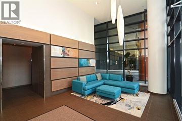 West Vancouver apartment for rent - A modern living room with a blue sofa and a glass wall.