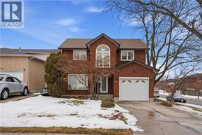 Hamilton apartment for rent - A house with a garage and a tree in front of it.