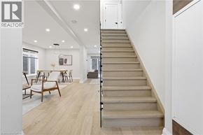 Hamilton apartment for rent - A staircase in a home leads up to a brightly lit living room.