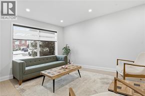 Hamilton apartment for rent - A living room with a green couch, a wooden coffee table, and a white chair.