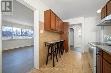 Ottawa triplex for rent - A kitchen with brown cabinets and a white oven.