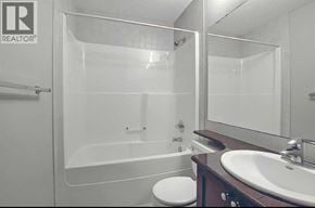 Calgary apartment for rent - A bathroom with a toilet, sink, and bathtub.