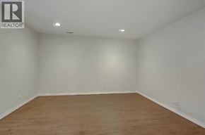 Calgary apartment for rent - A large empty room with wooden flooring and white walls.