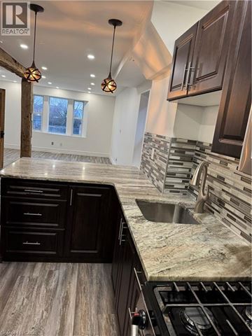 Hamilton apartment for rent - A modern kitchen with dark wood cabinets and a marble countertop.
