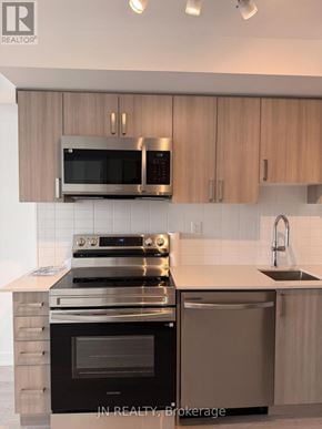 Pickering (Bay Ridges) condo for rent - A modern kitchen with a stove, oven, microwave, and cabinets.
