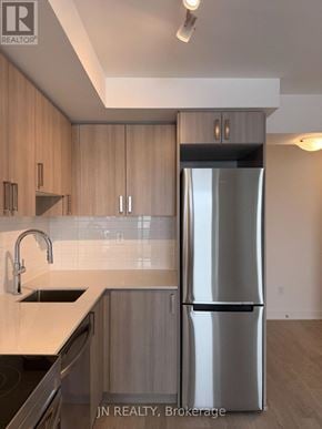 Pickering (Bay Ridges) condo for rent - A modern kitchen with wooden cabinets and a stainless steel refrigerator.