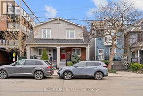 Toronto (Greenwood-Coxwell) duplex for rent - A kitchen with a black fridge and stove top oven.
