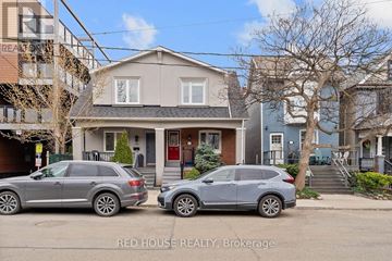 Toronto (Greenwood-Coxwell) duplex for rent - A kitchen with a black fridge and stove top oven.