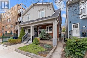 Toronto (Greenwood-Coxwell) duplex for rent - A kitchen with a black fridge and a window with blinds.