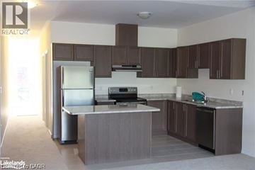 St. Catharines townhouse for rent - A kitchen with brown cabinets and a white counter top.