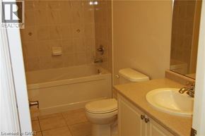 St. Catharines townhouse for rent - A bathroom with a toilet, sink, and bathtub.