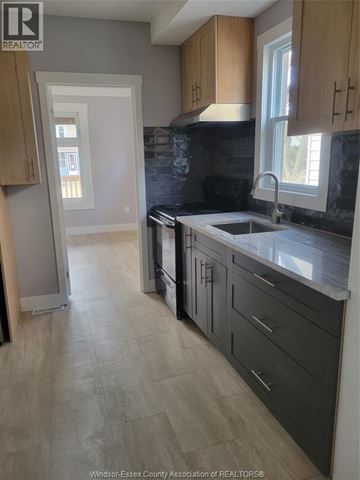 Windsor duplex for rent - A kitchen with wooden cabinets and a black counter top.