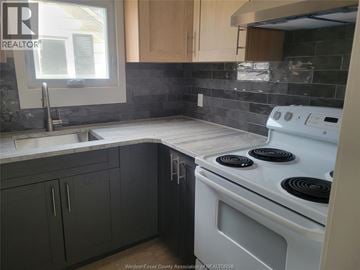 Windsor apartment for rent - A kitchen with a white stove top oven and a window.