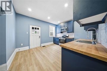 Brantford apartment for rent - A kitchen with a wooden counter top and blue walls.