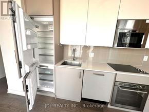 Toronto (Church-Yonge Corridor) condo for rent - A kitchen with white cabinets and a refrigerator with the door open.