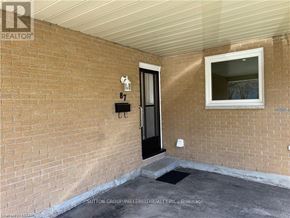 London North (North F) multi-family for rent - A brick wall with a black door and a small window above it.